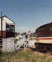 Looking west at Elgin west signalbox and level crossing. Class 47 and passenger train and token hoops exchange.<br><br>[Ewan Crawford //]