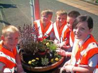 Crosshouse Primary School pupils Liam Orton, Kai Gallagher, Cameron Sinclair, Jack Ralston, and Emma MacDonald tending to one of their planters at Hairmyres station. [See adjacent news item]<br>
<br><br>[ScotRail 30/08/2012]
