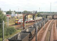 Shortly after a stop at Rutherglen station in August 2006 a Dalmuir - Lanark train heads towards Rutherglen Central Junction, passing the tail end of a train of westbound coal empties bound for Hunterston.<br><br>[John Furnevel 15/08/2006]