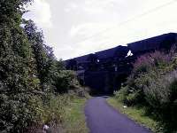 Looking South East, loaded coal hoppers from Hunterston trundle over the bridge at Elderslie Fly Under behind an EWS Class 66 going in the direction of Glasgow<br><br>[Graham Morgan 16/08/2006]