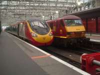 The rear of Virgin West Coast Class 390 Pendolino 390046 Virgin Soldiers and EWS Class 90 90034 with the terminated Caledonian Sleeper at Glasgow Central<br><br>[Graham Morgan 26/08/2006]