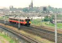 Train from Ayr to Glasgow passing Paisley Abbey in middle background.<br><br>[Brian Forbes //1992]