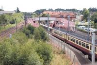 View south over Whifflet station in August 2006 as a service from Glasgow Central arrives at the platform. The line from Sunnyside Junction is over on the left.<br><br>[John Furnevel /08/2006]
