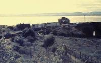 Sunset at Wormit, 1982. Equipment huts on northbound platform to the right of the surface bothy(with chimneys). The track and up platform are overgrown. <br><br>[Brian Forbes /10/1982]
