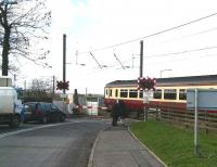 A westbound train for Glasgow Central leaving Kirknewton station on 5 March 2007 via the infamous half-barrier level crossing over the B7031. <br><br>[John Furnevel 5/03/2007]