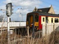The driver of a stopping train activates the half-barrier level crossing west of the station prior to leaving Kirknewton for Glasgow Central on 5 March 2007.<br><br>[John Furnevel 5/03/2007]