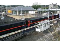 Old and new station buildings stand side by side at Markinch on 22 July as a southbound service pulls in.<br><br>[John Furnevel 22/07/2007]