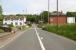 Approaching Dunragit level crossing from the south on 31 May 2007. The rear of the signal box can be seen on the right with the former station building and platform on the left beyond the entrance to the old goods yard.<br><br>[John Furnevel 31/05/2007]