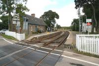 View northeast through Forsinard station on 27 August from the open level crossing. The former station building is now a visitor information centre run by the RSPB which has a reserve here and the young lady in blue watering the platform plants is a student from Norfolk doing a holiday job.<br><br>[John Furnevel 27/08/2007]