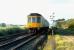 An ex-Cumbernauld class 107 DMU accelerates towards Greenfoot level crossing. The semaphores are now a thing of the past as are the 107s.<br><br>[Ewan Crawford //1989]