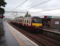 320 316 with a Helensburgh Central service arrives at Easterhouse on a wet 15 September.<br><br>[David Panton 15/09/2007]
