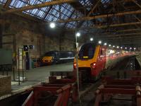 91128 of NXEC waiting to form the 0850 service to Newcastle at Platform 1 and 221140 of CrossCountry with the 0820 Newcastle service at Platform 2 of Glasgow Central on 29th December<br><br>[Graham Morgan 29/12/2007]
