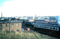 View east towards Haymarket station in September 1986 from the former Caledonian Railway overbridge carrying the Granton and Leith line running south from Murrayfield station. An Edinburgh bound class 27 on the line from Fife takes its train past a DMU manoevering in the sidings just to the east of Haymarket depot.<br><br>[David Panton /09/1986]