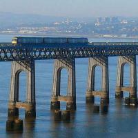 This Edinburgh 170 is passing the locus of the former distant semaphore signal for Tay Bridge South Junction. Ninewells Hospital and the three blocks of high flats at Blackness are visible on the north shore beyond the train.<br><br>[Brian Forbes 12/01/2008]