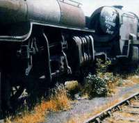 A Crab and a Bulleid Pacific stand face to face in the sidings at Woodhams scrapyard, Barry, on 26 July 1980. Locomotive 34073, <I>249 Squadron</I>, for whom the Pacifics smokebox door has been reserved, currently awaits restoration on the Mid Hants Railway.<br><br>[Colin Alexander 26/07/1980]