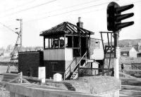 The signalbox at Cardross was set alight very late in the day of 26 April 1971 by a drunk passenger who had just arrived on a Helensburgh bound train. The remains of the box are seen early in the morning of 28 April 1971. The signalman at the time of the incident was a friend, Jack Vickers. A temporary control centre was set up in an old waiting room on the up platform and an interlocked single lever ground frame was installed in front of the former box to release the level crossing gates. The arrangement lasted until the North Clyde resignalling was completed following which the area was controlled from Yoker.<br><br>[John McIntyre 28/04/1971]