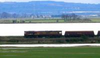 Running along the riverbank of the Forth between Kincardine and Longannet, the first train of 70 ton coal hoppers to run over the newly reopened route nears Longannet power station.<br>
In the distance stands the Falkirk Wheel.<br><br>[Brian Forbes 05/04/2008]