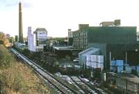 The site of Alloa (New) station in November 1985, then covered by the brewery complex. Remarkably, only the railway line survives in the modern view. The new station platform follows the course of the trackside railings and the new shelter is roughly at the site of the white storage tanks. [See image 18650]<br><br>[Mark Dufton /11/1985]