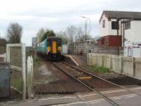 156473 waits for the crossing barriers to close before leaving Moss Side for Kirkham on a Blackpool South to Colne service. Although substantially modified the house in the picture is the original station house.  <br><br>[Mark Bartlett 26/04/2008]