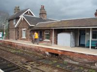 The signaller walks down Hammerton platform to operate the crossing gates. The small grey wooden building houses the lever frame for the points and semaphore signals and the rodding and wires can be seen below. The block instruments are in the office behind and the single line token pouches are just inside the doorway.<br><br>[Mark Bartlett 28/04/2008]