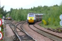 A silver power car on a white stripe HST 125 set heads south at Ladybank on 18 May 2008, passing an EWS class 66 waiting for the road on the Perth line with a ballast train.<br><br>[Brian Forbes 18/05/2008]