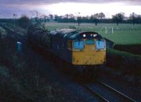 Dawn struggles to break in December 1985 as a train of molasses bound for Menstrie leaves Alloa marshalling yard. The yard was closed two years later when a new run around loop was installed at Cambus<br><br>[Mark Dufton /12/1985]