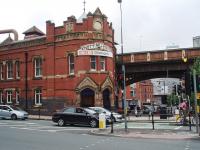 Deansgate station was known as Knott Mill and Deansgate until 1969, as can be seen from the very ornate panel above the street level entrance. The station is on the busy two track bottle neck section between Castlefield Junction and Manchester Piccadilly. <br><br>[Mark Bartlett 07/07/2008]