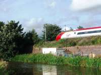 A Pendolino speeds north through Garstang and Catterall. The retaining wall by the Lancaster Canal once supported the Garstang and Knott End Railway track alongside the main line. <br><br>[Mark Bartlett 21/07/2008]