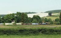 1215 ASDA intermodal heading east along the banks of the River Tay at Seggieden. The Sidlaw Hills with a field covered by a crop sheet are seen behind the DRS class 66 locomotive.<br><br>[Brian Forbes 05/06/2008]