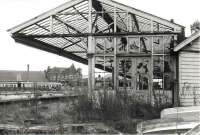 Standing on the derelict platform 1 of the old <I>Manors North</I> in 1983 as a 101 DMU pulls into platform 6 of <I>Manors East</I> on a Morpeth service. Part of the old clock tower on the west side of the station can just be seen top right and the wooden (white) footbridge, that provided the link between the derelict and operational platforms at this time, can be seen through the broken windows of the canopy, as can the curve of the Tyne Bridge beyond.<br><br>[Colin Alexander //1983]