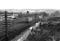 Looking south from the area behind Ferryhill signal box on 21 April 1973, showing the ECML curving away to the south over the River Dee and the lines off to the right leading to Ferryhill MPD. A class 25 is seen running into the depot, about to pass a class 27 coming off shed and heading for Aberdeen station.<br><br>[John McIntyre 21/04/1973]
