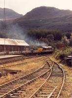 A 37 with aluminium slabs makes a smoky departure for the south from Crianlarich.<br><br>[Ewan Crawford //1990]