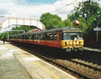 All windows open as a class 303 leaves Williamwood and heads for Neilston in July 1999.<br><br>[David Panton 19/07/1999]