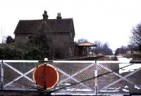 Looking north over the level crossing in Station Road, Isfield, Sussex in 1974. The view is towards Uckfield, to where the line was cut back in 1969, resulting in the closure of Isfield station. On a brighter note the site is now the HQ of <i>The Lavender Line</i> preservation group, while there is growing pressure for the reopening of the through route between Uckfield and Lewes.<br><br>[Ian Dinmore //1974]