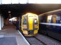 An Edinburgh - Aberdeen service, formed by 158712, peeps out from below the bridge at Arbroath station on 12 February 2008 and is reflected in the coaches of a National Express HST set standing in the adjacent platform.<br><br>[Sandy Steele 12/02/2008]