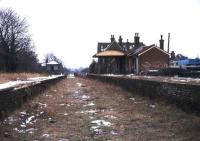 The derelict station at Isfield, Sussex, in the winter of 1974, almost 5 years after closure. View south towards the level crossing and the former through route to Lewes. [See image 40376] <br><br>[Ian Dinmore //1974]