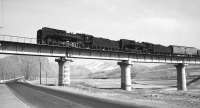 A pair of QJ 2-10-2 locomotives crossing a bridge in the Jing Peng pass, north east China, with a heavy freight. Photographed on 20 February 2002.   <br><br>[Peter Todd 20/02/2002]