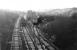 Narrow gauge interchange alongside Gathurst station in November 1978 with 25105, on a pick up freight, shunting gunpowder vans in a frosty Gathurst yard while the coal empties from Southport stand on the running line. The yard was linked by a narrow gauge railway that crossed the Douglas Valley on a steel viaduct (off to the right), to a nearby Nobel's explosives factory. [See image 21337]. The Industrial Railway Society 1973 handbook shows a fleet of six 4wDM Ruston gauge locos were based here and some narrow gauge wagons can be seen outside the transhipment shed. One of these wagons is being reconstructed by the Moseley Railway Trust in Staffordshire to work alongside one of the Gathurst Rustons, No.7, also preserved there. Gathurst station can still be seen from the M6 motorway viaduct in the background but the yard and narrow gauge line are no more. <br><br>[Mark Bartlett 28/11/1978]