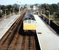 A class 25 with an inspection saloon runs south through Appleby station around 1983. The link to the former NER Eden Valley line runs off to the right in front of the signal box in the background.<br><br>[Colin Alexander //1983]