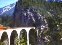 The western portal of Landwasser Tunnel showing the viaduct meeting the cliff face, taken from a westbound train in August 1998. To the left of the picture is a flat wagon and the last coach of the train.<br>
<br><br>[Fraser Cochrane /08/1998]