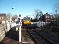 The guard has operated the level crossing barriers from the platform at Moss Side and 142003 departs for Kirkham on a Colne service. In the other direction the half barriers are activated automatically by the approaching train.<br><br>[Mark Bartlett 07/02/2009]