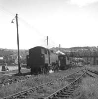 The sidings at Gourock in July 1963, with locomotives awaiting the call to take over trains back to Glasgow Central. Meantime one of the crews takes a break and a well earned cuppa alongside the River Clyde.<br><br>[Colin Miller 12/07/1963]