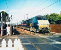 Teatime at Kingsknowe station on a warm summer's afternoon in July 1999 as a GNER Kings Cross - Glasgow Central service runs west over the level crossing.<br><br>[David Panton /07/1999]