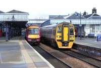 170 478 is halted at Stirling with a Glasgow to Dunblane service while Alphaline-liveried 158 871 pulls out for Edinburgh on 4 March 2009.<br><br>[David Panton 04/03/2009]