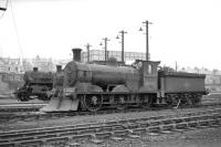 Looking across the running lines at a lineup of locomotives standing outside Bathgate MPD in April 1965, with snowplough-fitted Holmes J36 0-6-0 no 65267 to the fore. 76104 and 65282 stand in the background.   <br><br>[Robin Barbour Collection (Courtesy Bruce McCartney) 16/04/1965]