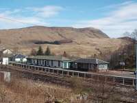 Crianlarich station, viewed from the adjacent A82 main road, on a sunny Sunday morning looking north towards the junction with the Oban line. The well known refreshment room occupies the central, white painted, building. <br><br>[Mark Bartlett 29/03/2009]