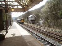 A Manchester bound service, formed by Northern unit 158872, passes the signal box at Hebden Bridge as it draws to a halt in the Up platform. The box has recently been refurbished and controls colour light signals on a section of the Calder Valley line.<br><br>[Mark Bartlett 04/04/2009]