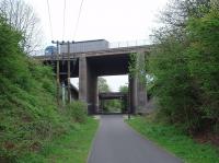 This bridge over the Lancaster to Wennington direct line was built in 1960 to carry the Lancaster By-pass, later the M6 Motorway. The railway closed only six years later however and this view looks east towards Halton station along the trackbed cyclepath. The lorry is just about to cross the River Lune on the much more impressive motorway viaduct. Map Ref SD 495644.<br><br>[Mark Bartlett 24/04/2009]