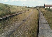 Looking east at Westcraigs in pre footpath days. Indeed at this time very few scrambler bikes roared up and down the trackbed. Where will they all go when the line re-opens? Today only one platform remains intact here following the conversion into a footpath.<br><br>[Ewan Crawford //1988]