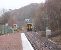 The eastern approach to Connel Ferry, formerly a three platform junction station but now just a plain single line with a short siding. The sidings in the oil depot alongside the platform are now lifted. The remaining siding is seen here occupied by a civil engineering machine that had probably been used in connection with the resleepering that could be seen in the station area. 156467 approaches heading for Oban.<br><br>[Mark Bartlett 27/03/2009]